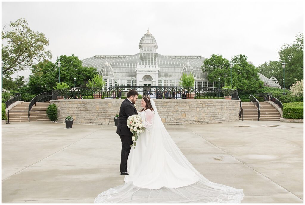 Bride and Groom looking at each other standing in front of the Franklin Park Conservatory