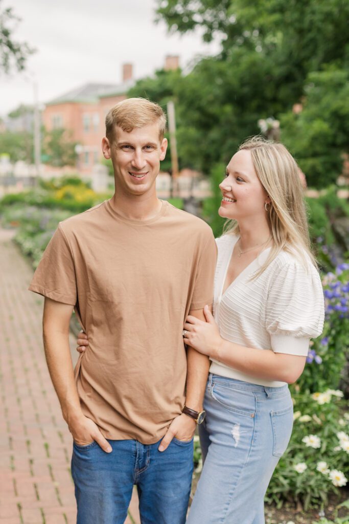 A bride to be is smiling at her soon to be husband while posing for a photo during their engagement session at one of the best engagament session location in Columbus - Schiller Park 